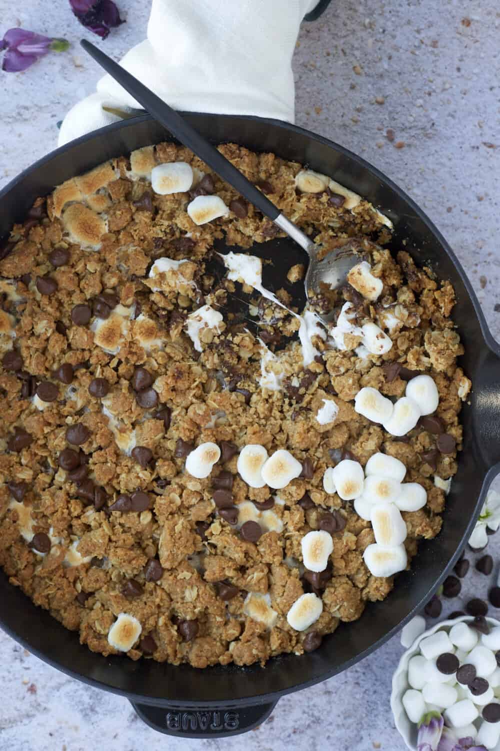 s'mores oatmeal cookie skillet with a spoon dipped in 