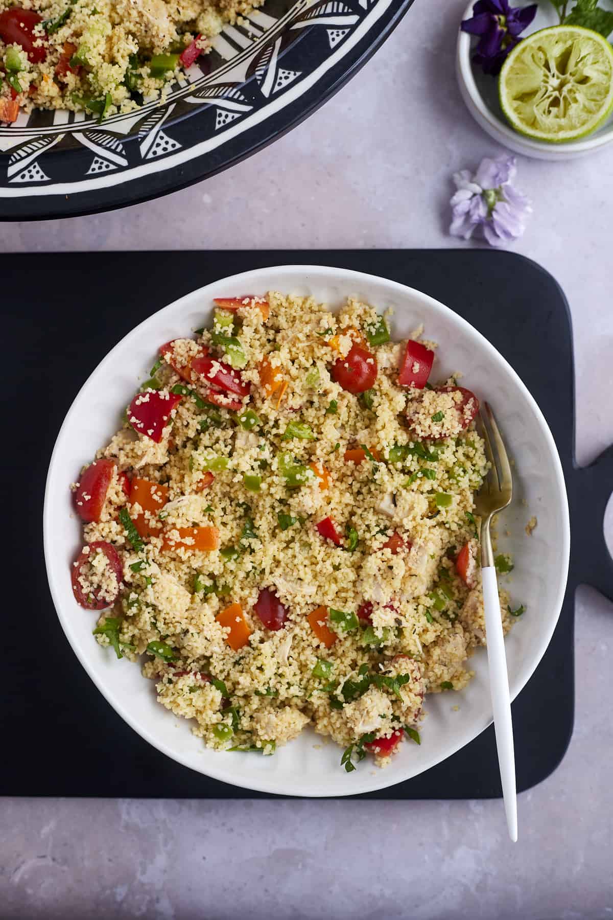 a large bowl of couscous salad with a fork on the side