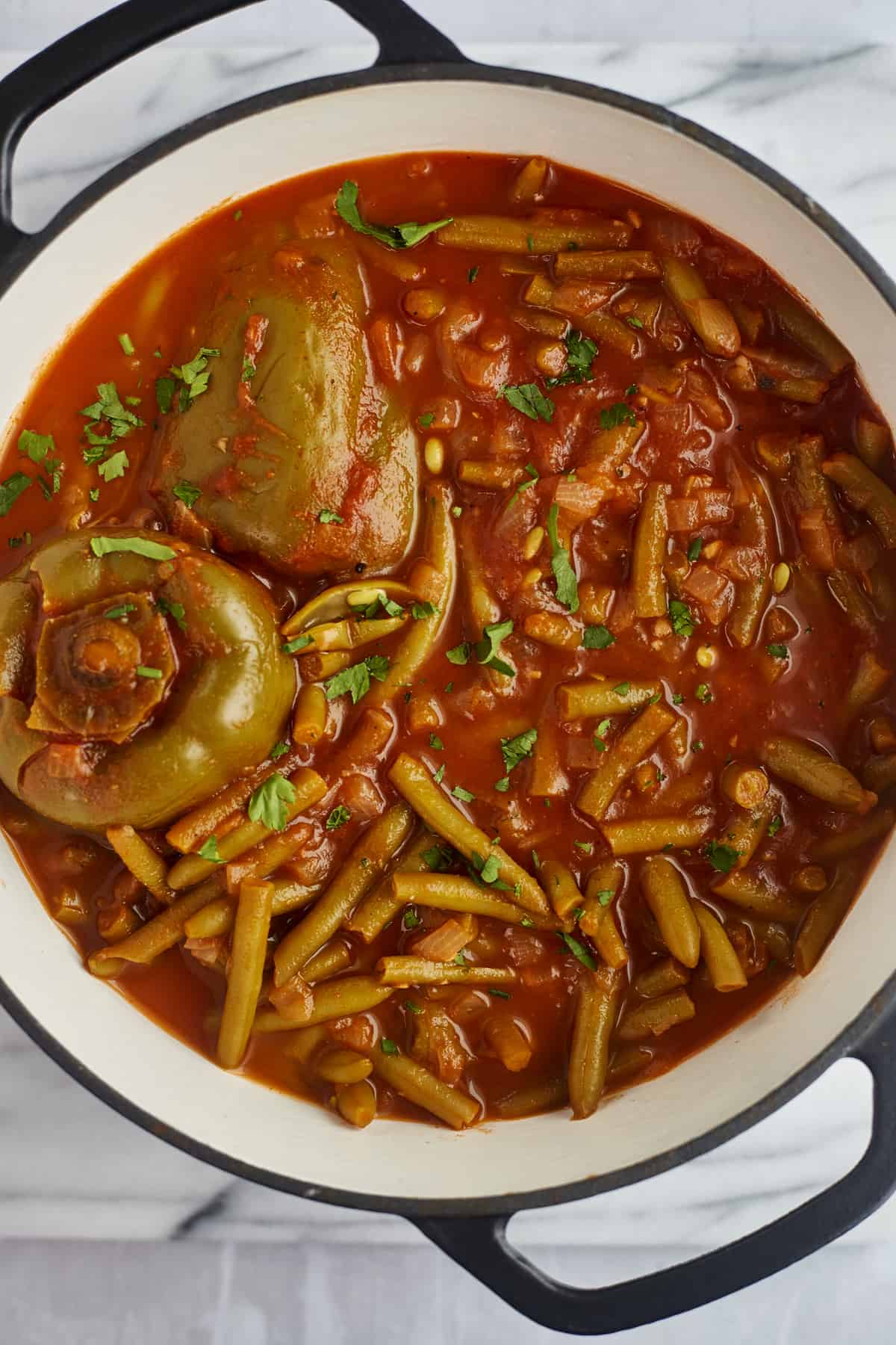 green bean stew with stuffed bell peppers in a large pot 