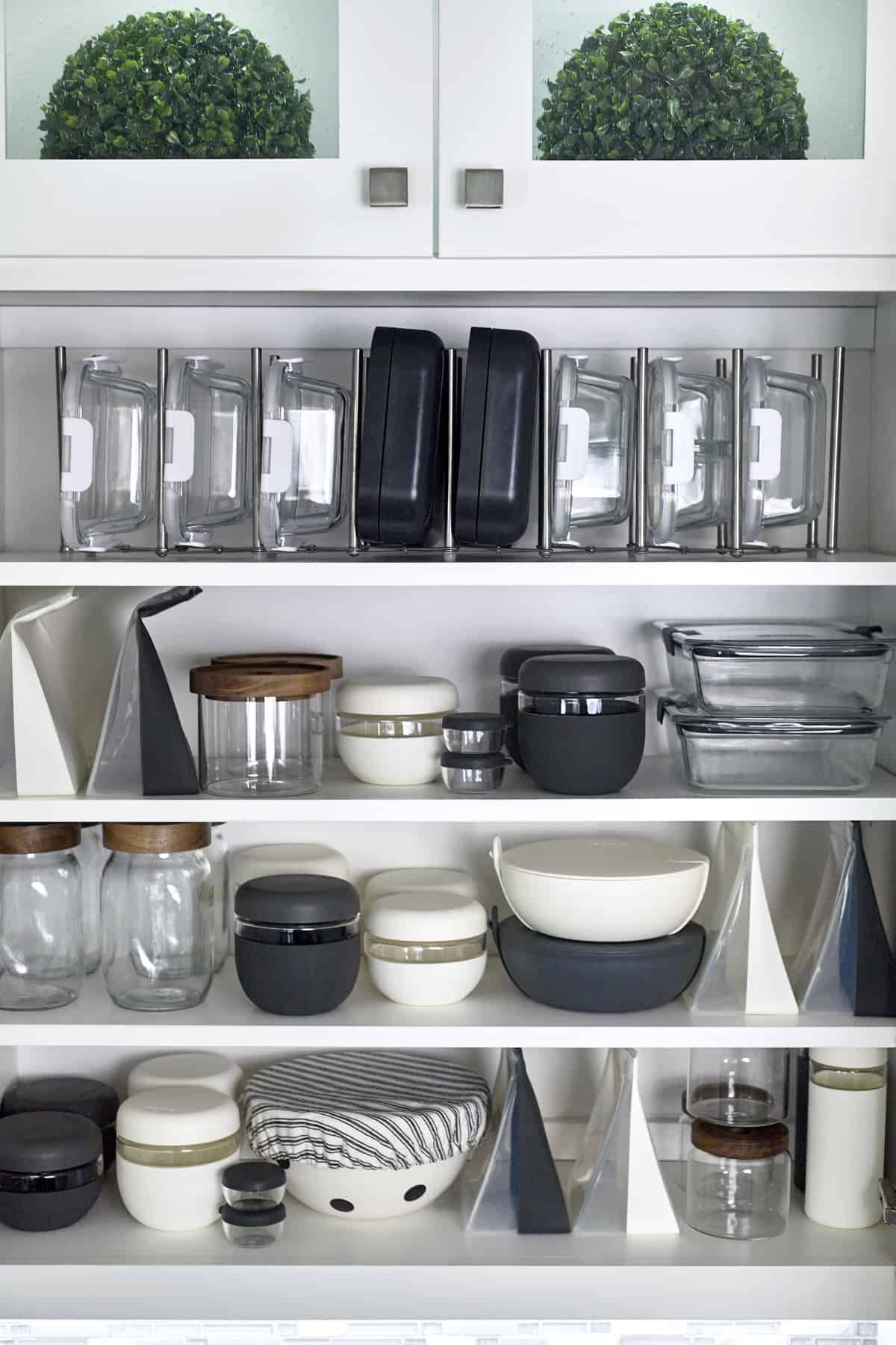 A cabinet full of organized food storage containers. 