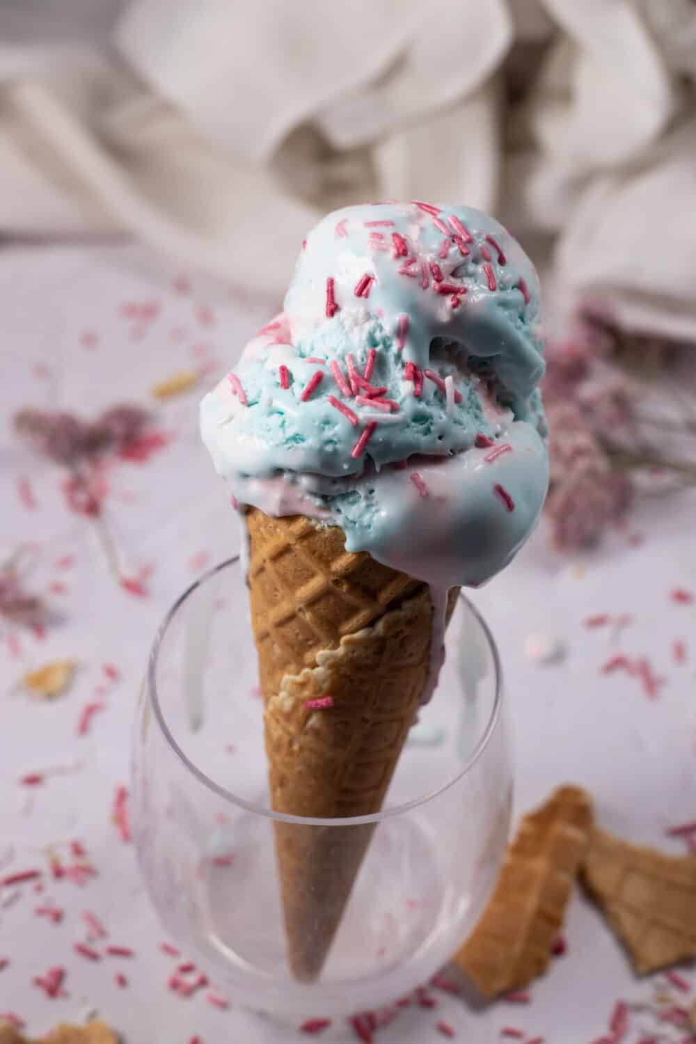 an ice cream cone stuffed with homemade cotton candy ice cream in a wine glass