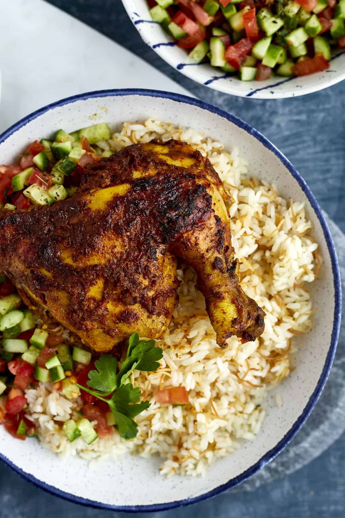 Middle Eastern chicken over vermicelli rice with tomato and cucumber salad on the side 