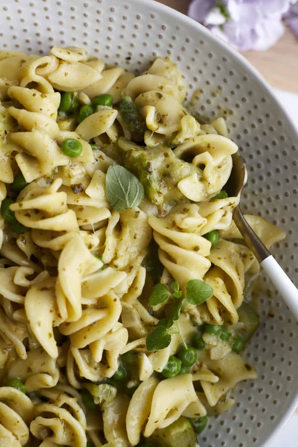 close up image of cooked pasta with pesto and veggies