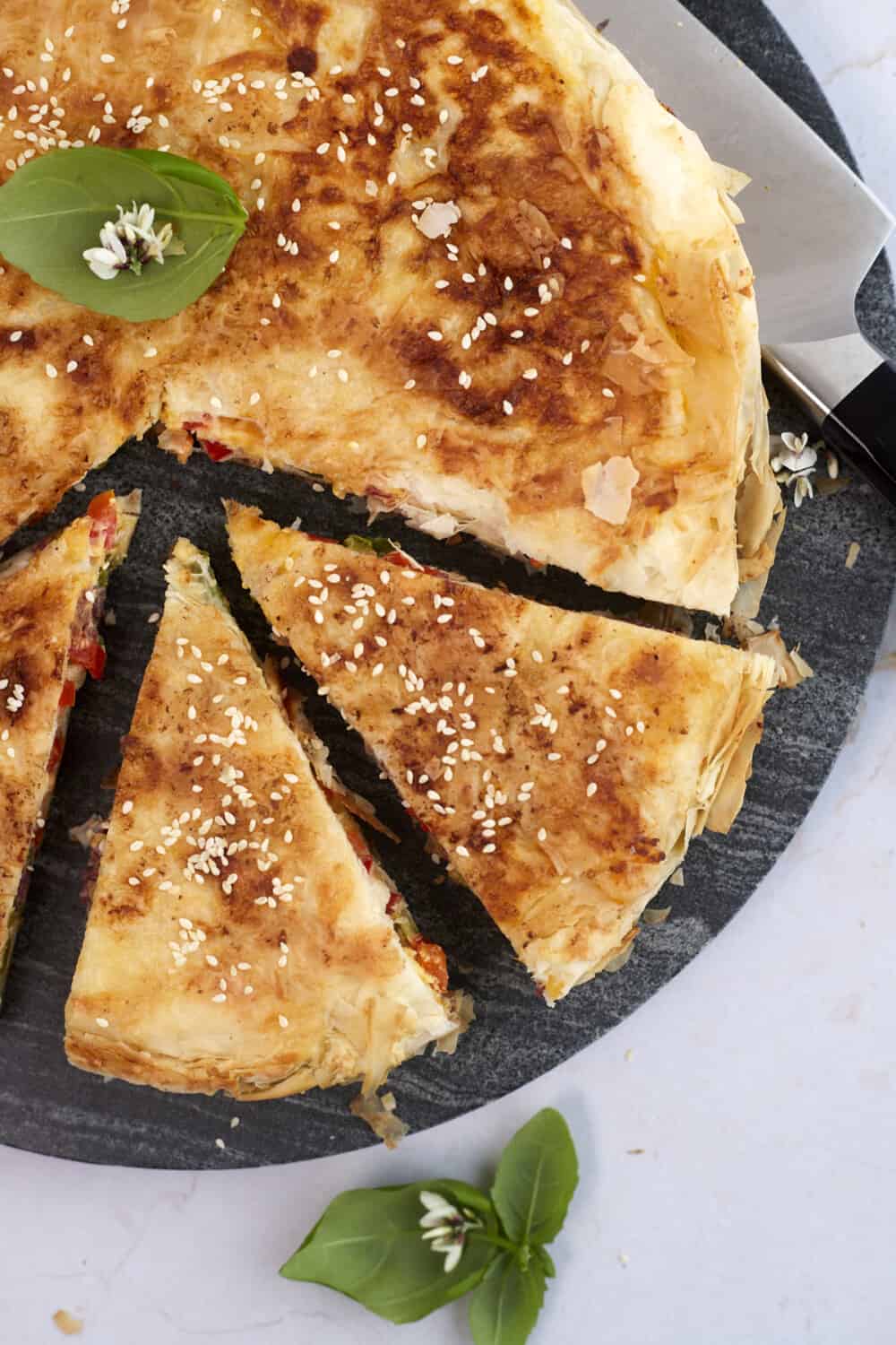 veggie phyllo pie with three pieces sliced 