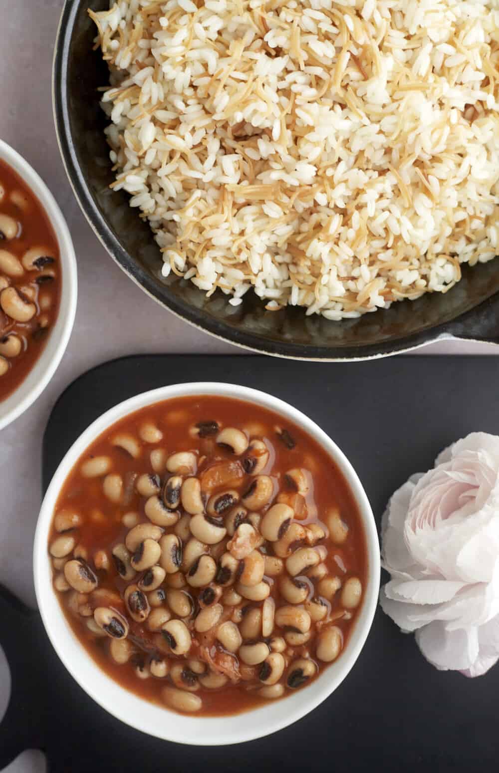 bowls of black-eyed pea stew and a large pot of vermicelli rice
