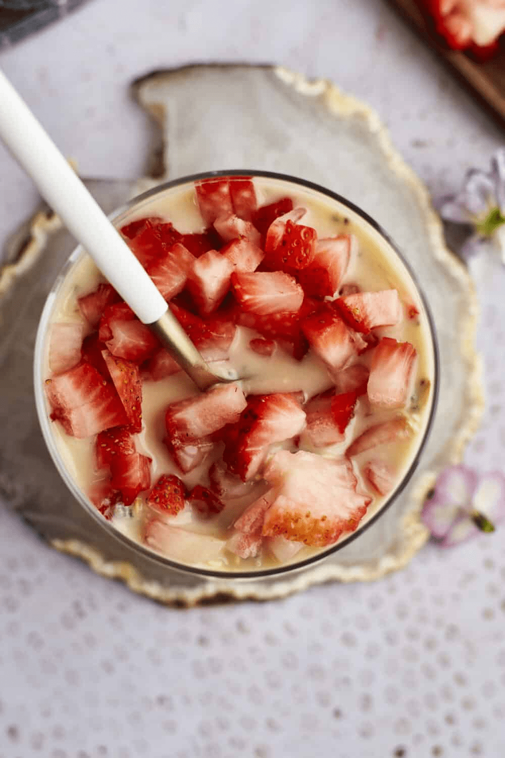 strawberry overnight oats in a glass with spoon