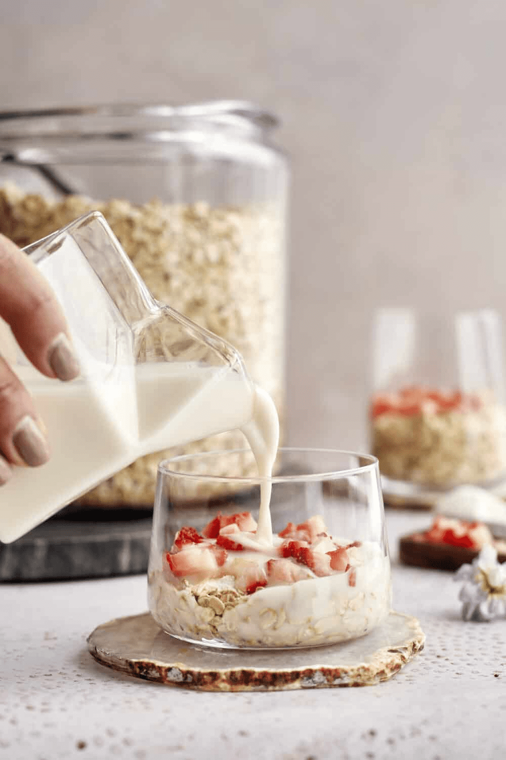 Milk being poured over oats and strawberries