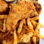 chicken tenders on a baking tray with fries