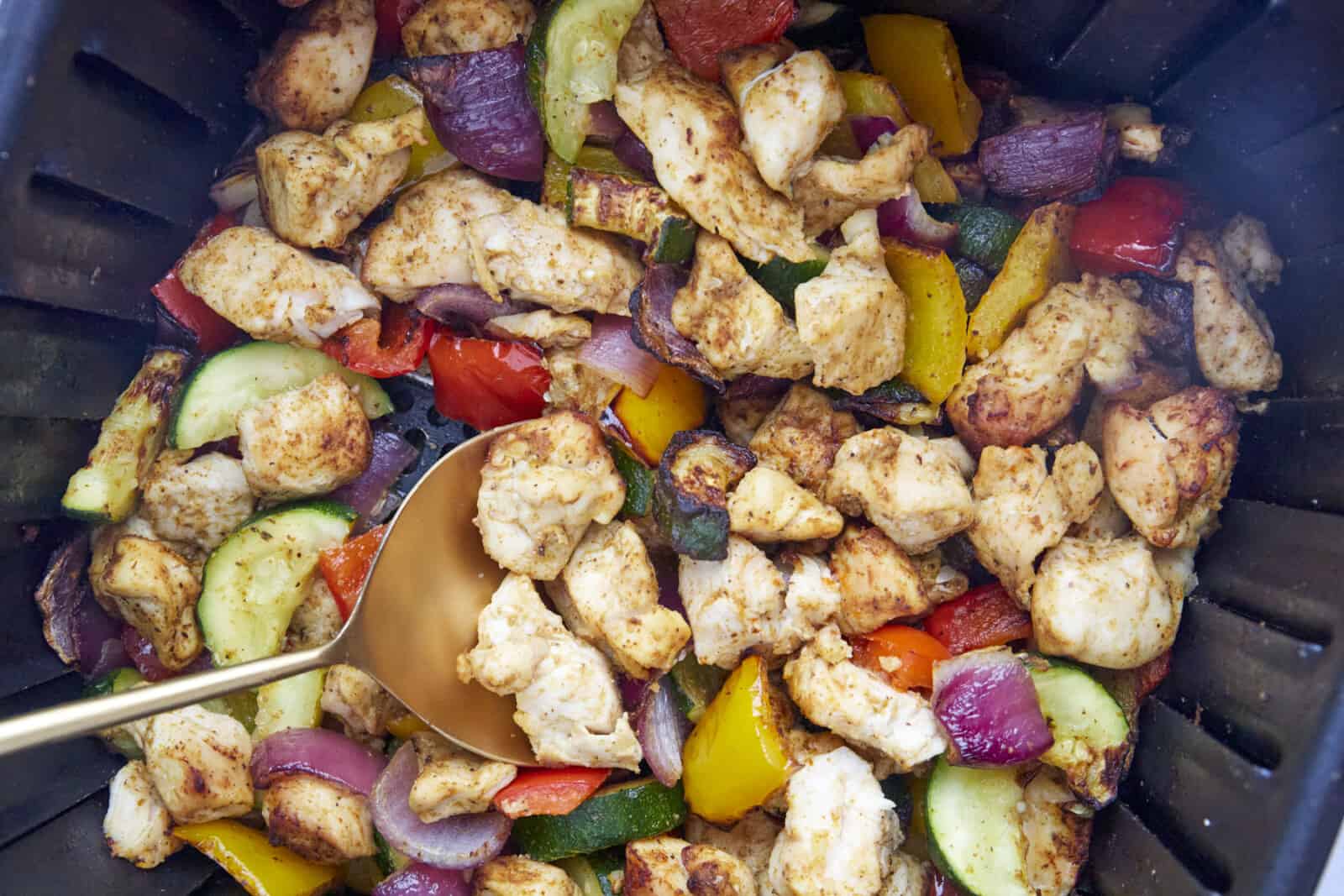 cooked chicken and vegetables in an air fryer