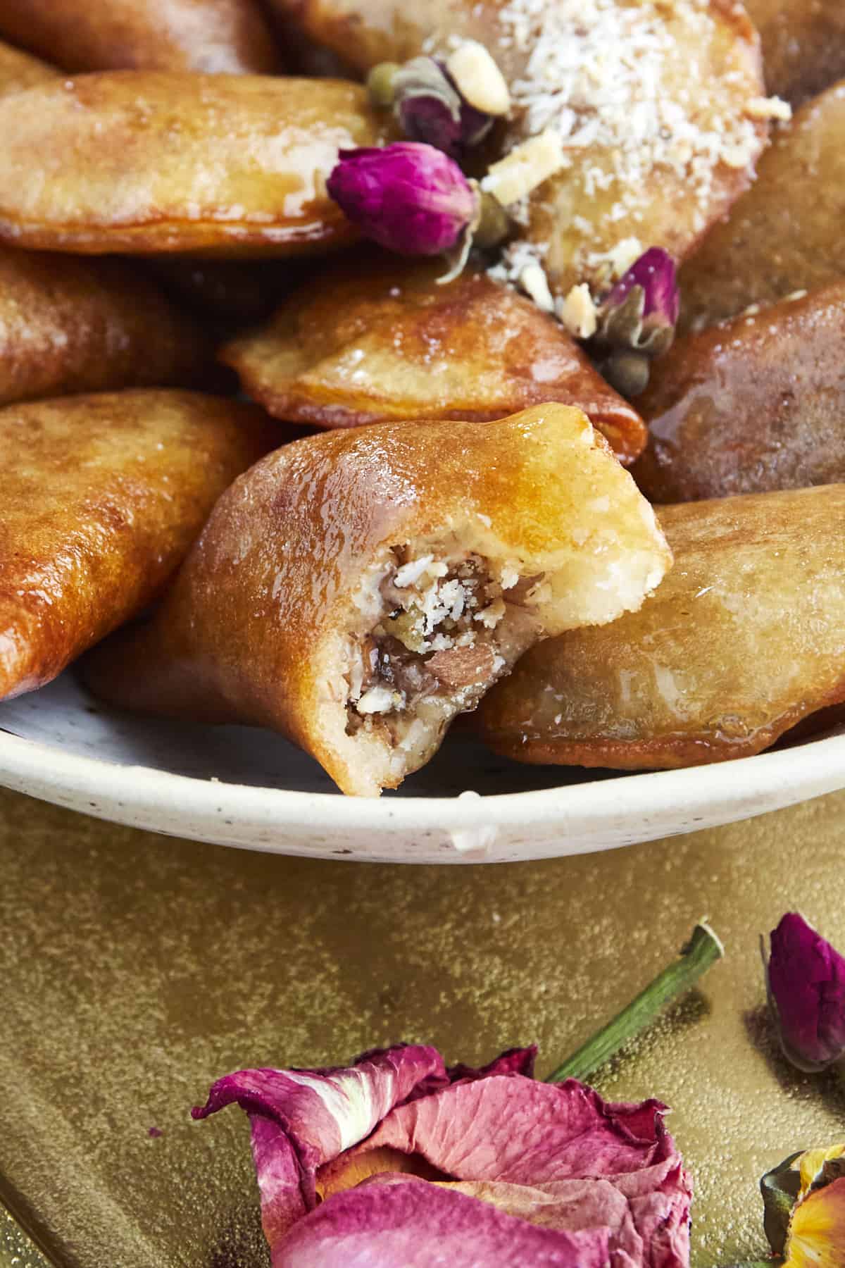 close up image of a plate full of qatayef with one piece missing a bite