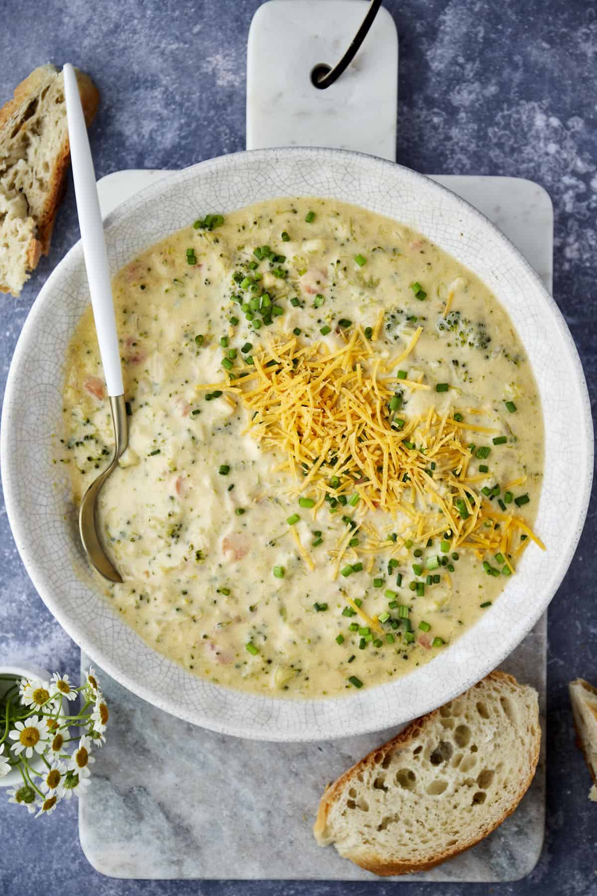 A bowl of broccoli and cheese soup with a spoon sticking out. 