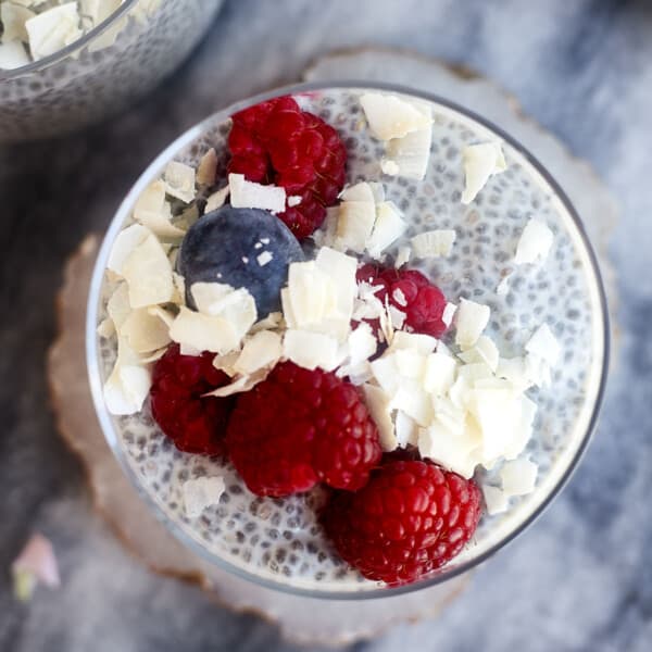 coconut chia pudding topped with blueberries, raspberries, and coconut flakes