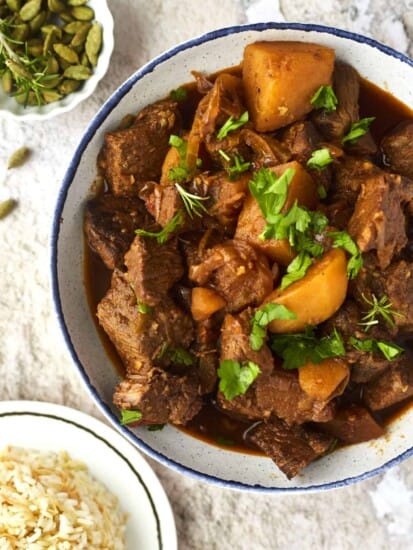 A bowl of Middle Eastern beef stew with potatoes and carrots.