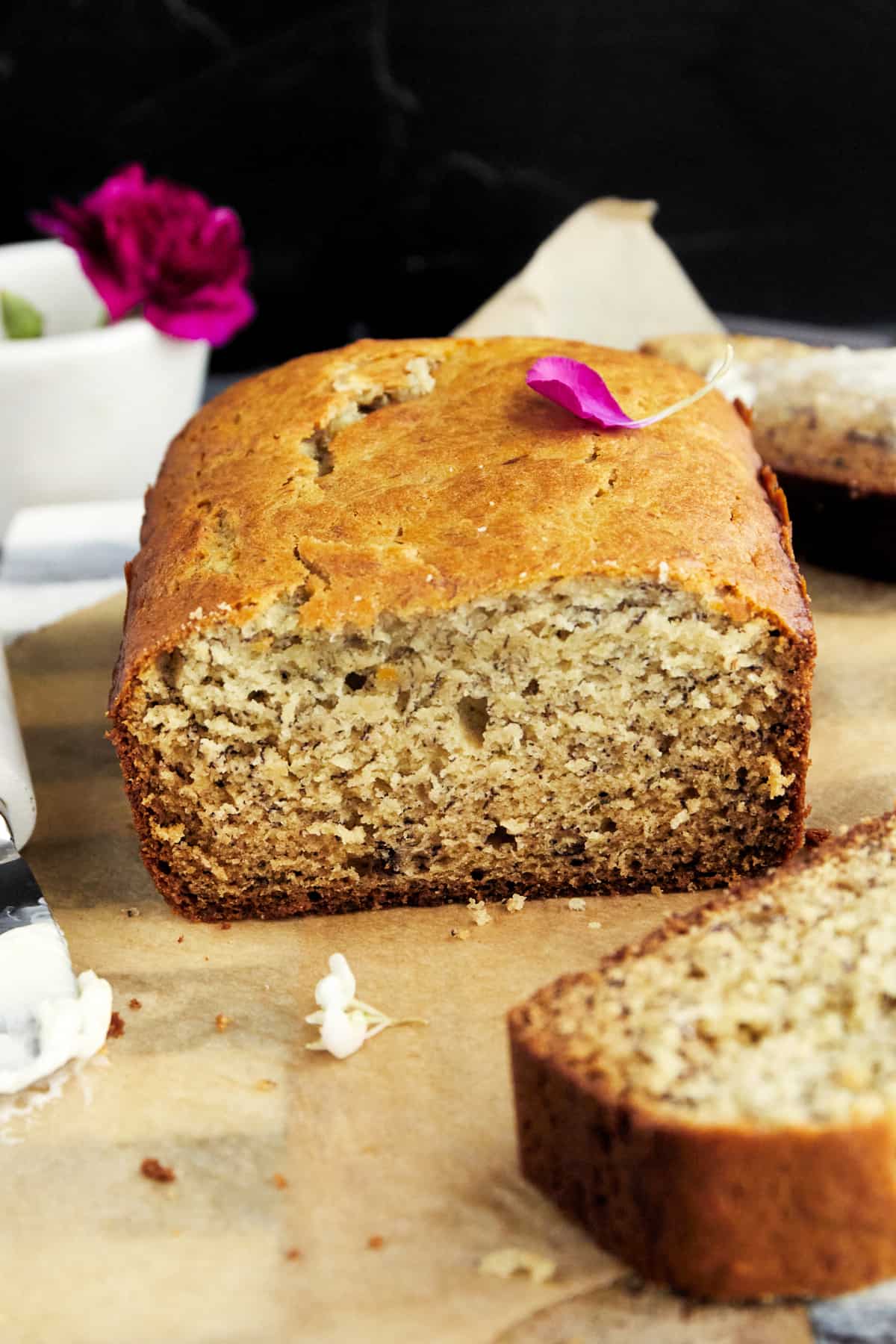 side image of a loaf of one bowl banana bread with a slice missing from the end
