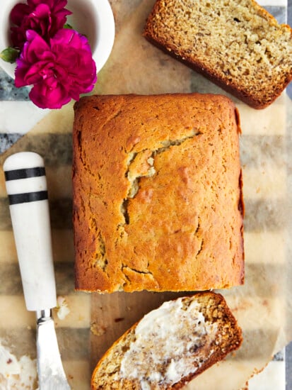 a loaf of one bowl banana bread with a buttered slice next to it