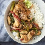 a bowl of white rice topped with black pepper chicken stir fry