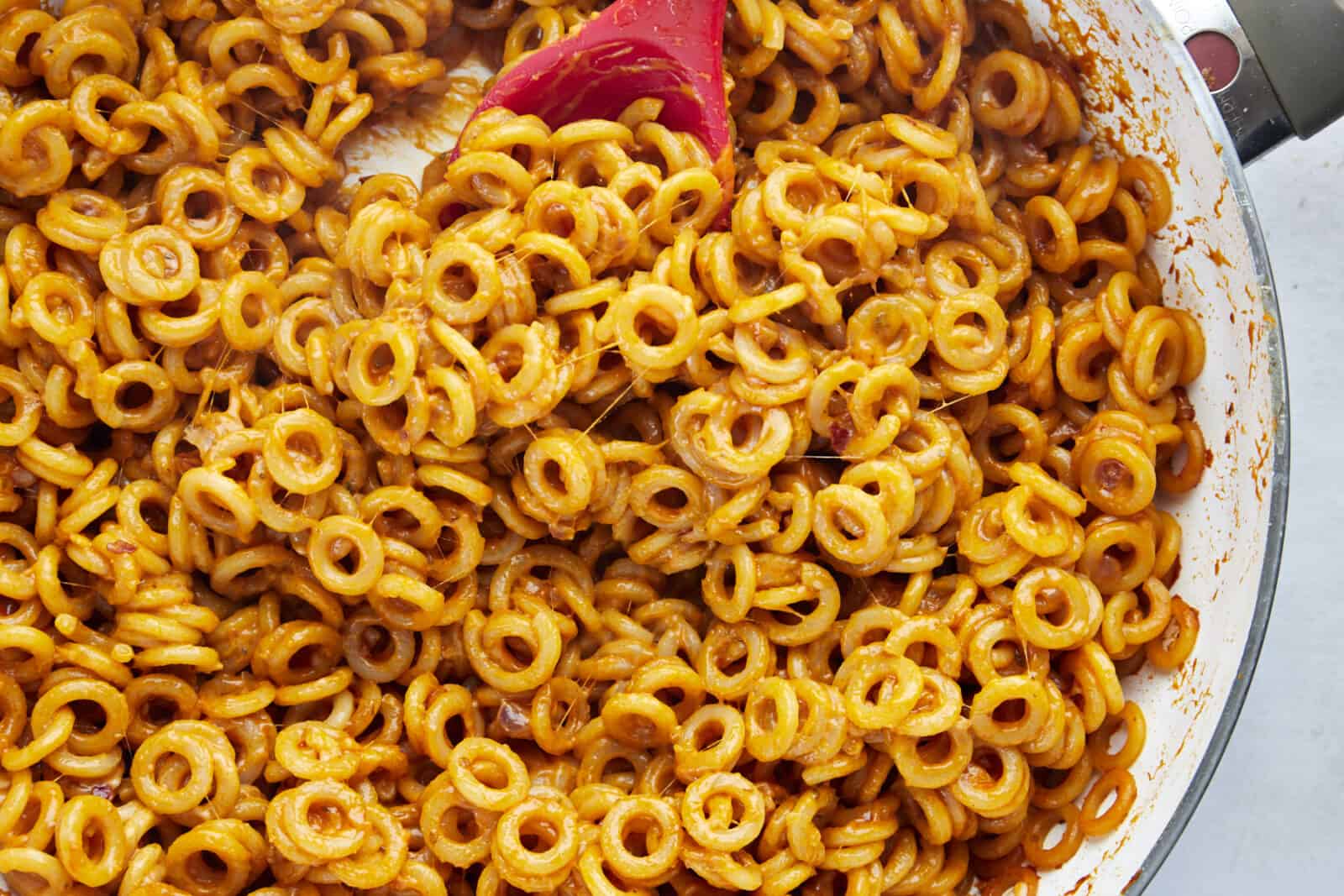 circular noodles with a tomato cheese sauce 