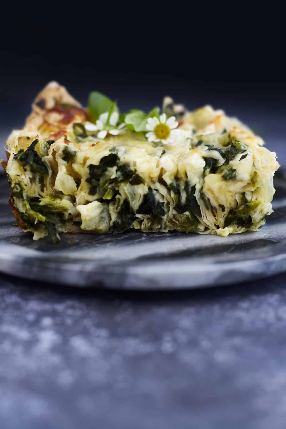 a slice of crinkle phyllo stuffed with a cheesy spinach mixture.