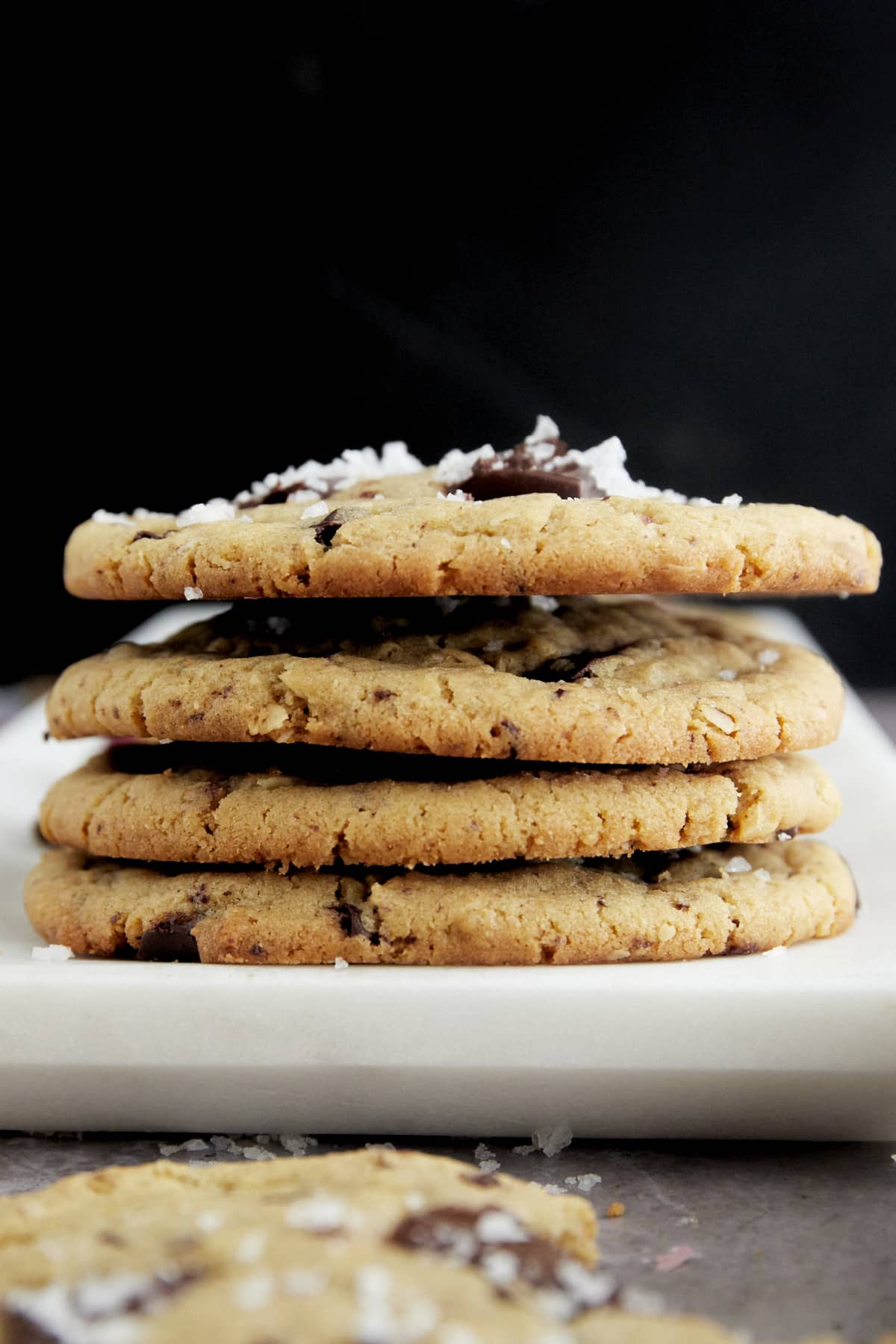 a stack of 4 salted tahini chocolate chip cookies on a plate