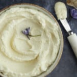 Lebanese garlic sauce in a bowl with a spreader next to it