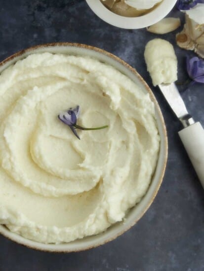 Lebanese garlic sauce in a bowl with a spreader next to it