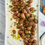 a platter of whipped feta topped with roasted Greek potatoes