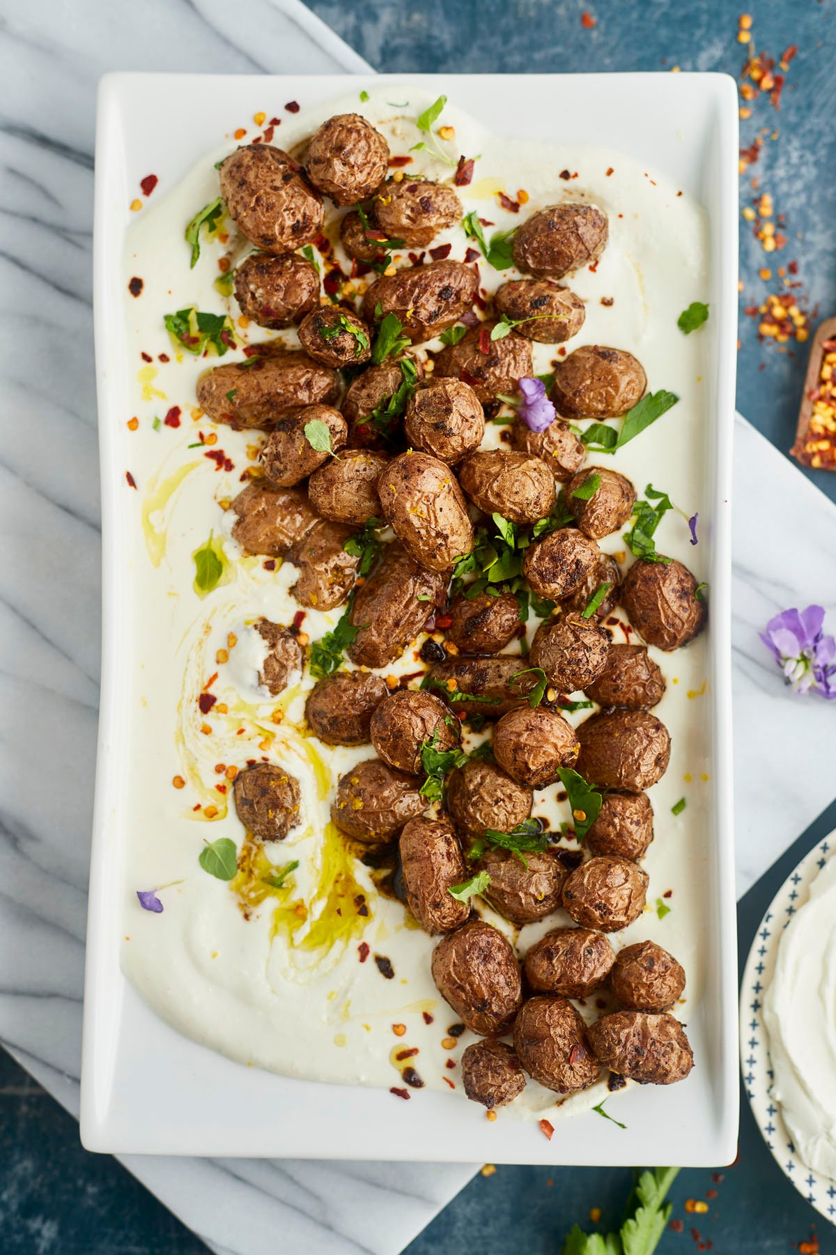 a platter of whipped feta topped with roasted Greek potatoes 