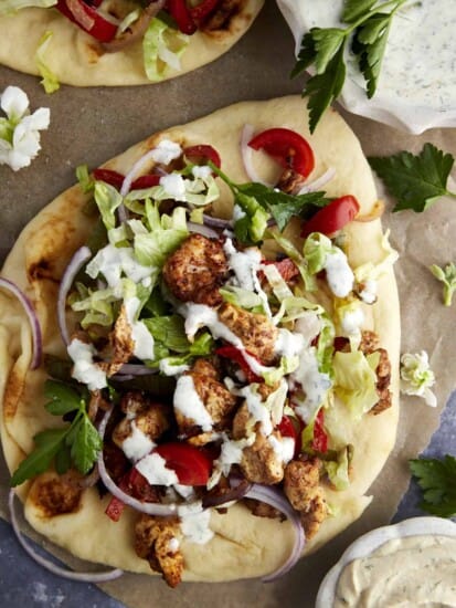 Air fryer chicken shawarma wrap topped with lettuce, tomatoes, and tzatziki.