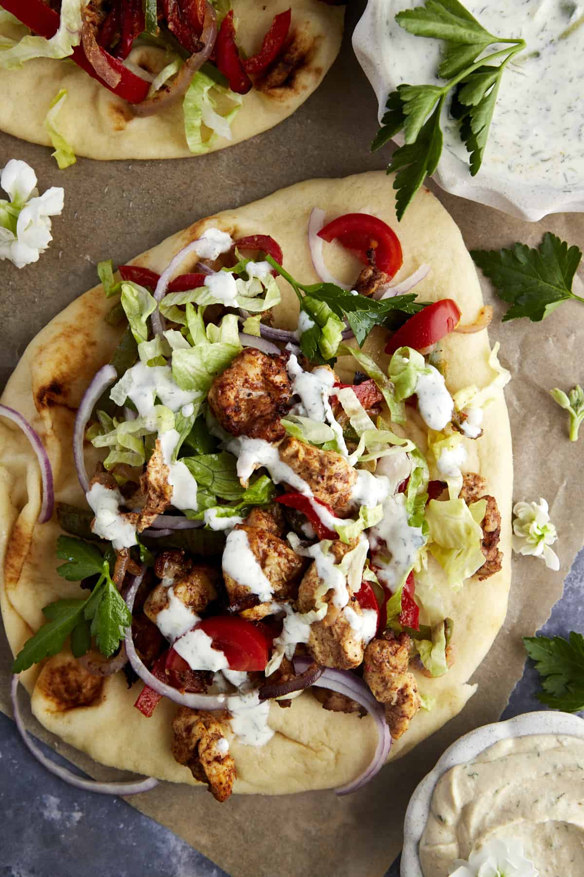 Air fryer chicken shawarma wrap topped with lettuce, tomatoes, and tzatziki.