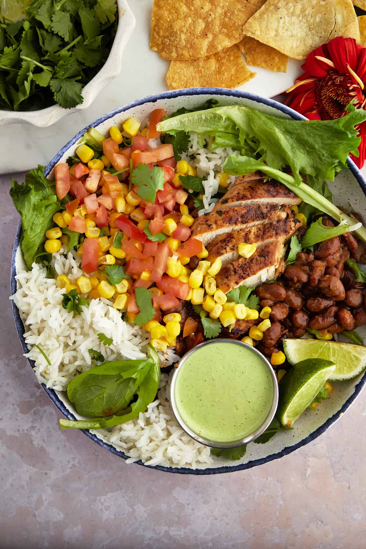 a bowl of southwest chicken salad with a container of cilantro dressing on top.