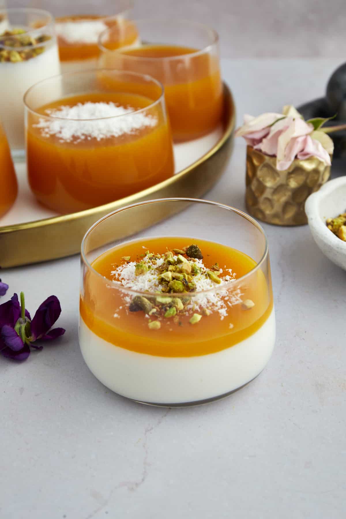 A pot of Muhallebi Amardeen Pudding topped with coconut flakes and pistachios.