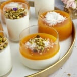 Pots of Muhallebi Amardeen Pudding topped with coconut flakes and chopped pistachios.