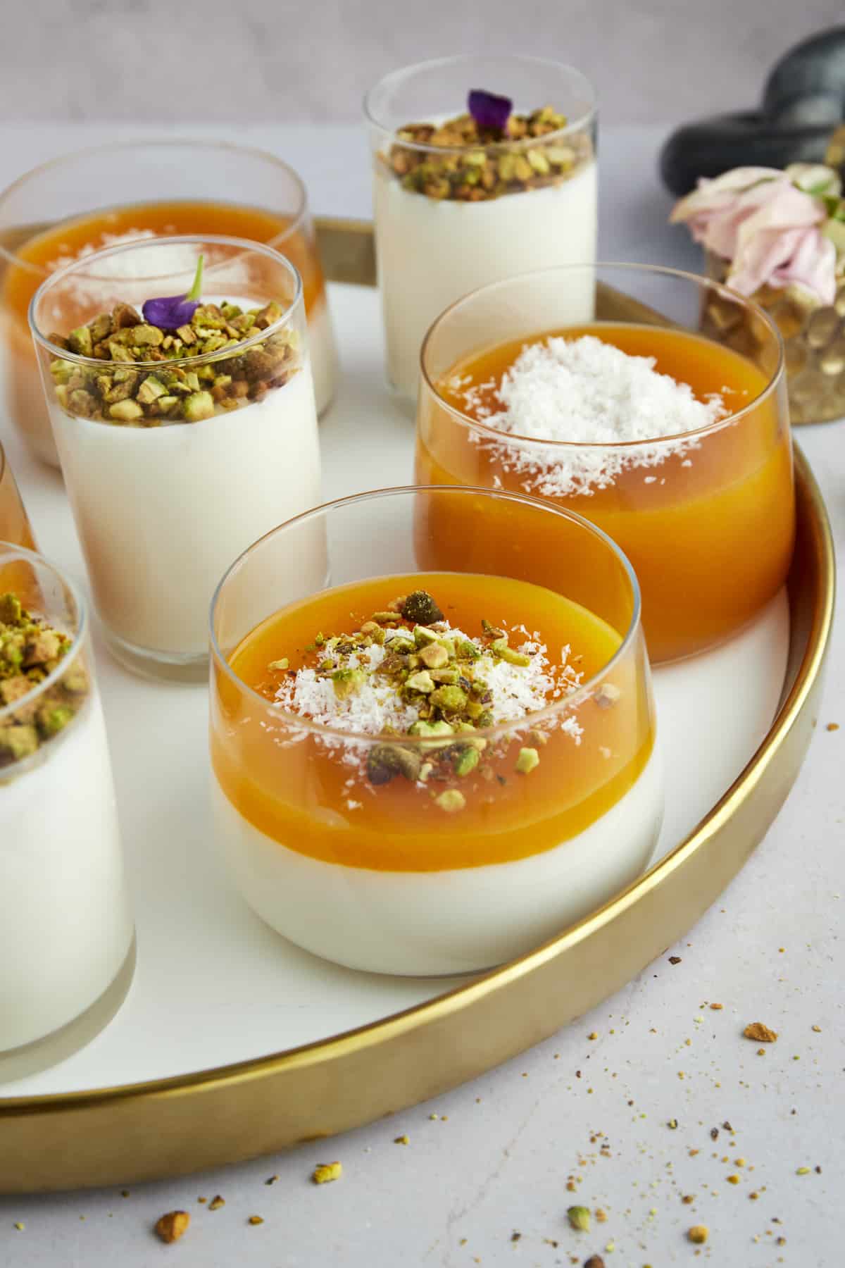 Pots of Muhallebi and Muhallebi Amardeen Pudding topped with coconut flakes and chopped pistachios. 