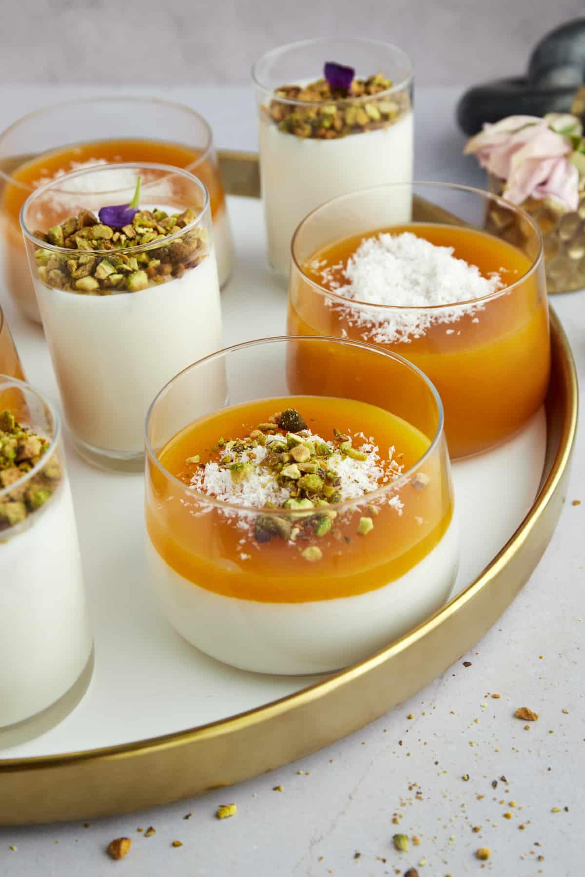 Pots of Muhallebi and Muhallebi Amardeen Pudding topped with coconut flakes and chopped pistachios.