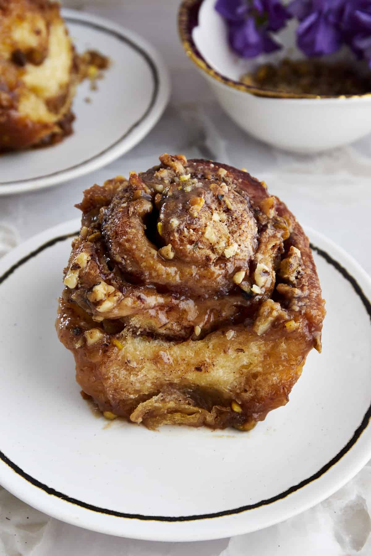 a pistachio walnut cinnamon roll with syrup on a plate