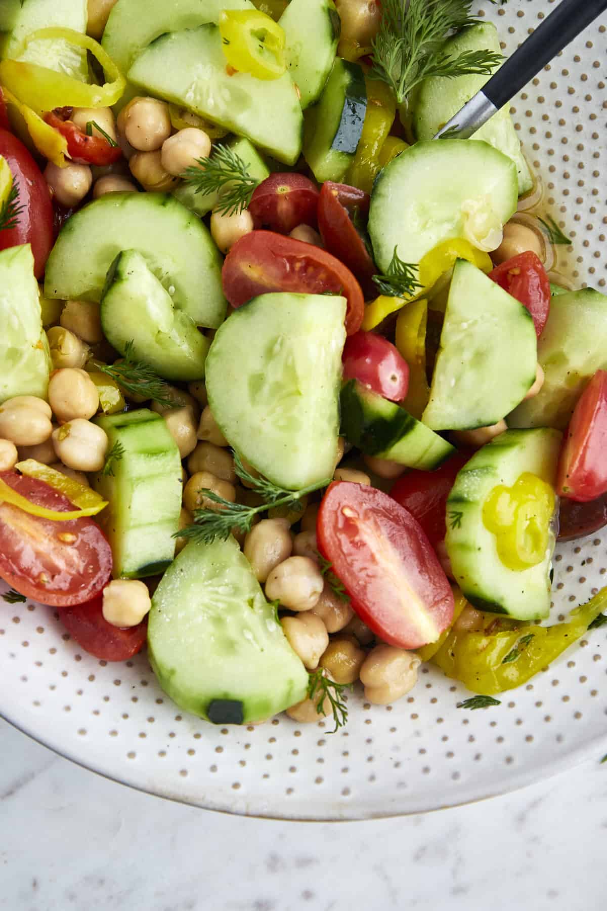 a bowl of chickpea salad with tomatoes and cucumbers
