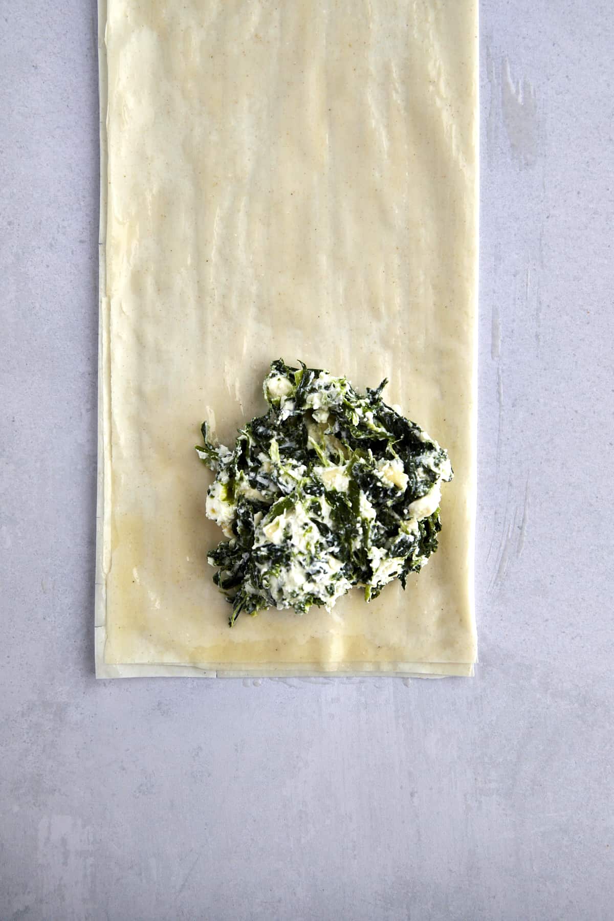 A dollop of spinach cream cheese filling over buttered layers of phyllo dough. 