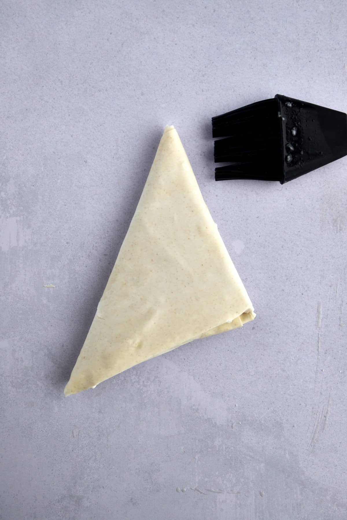 A triangle of raw phyllo dough. 