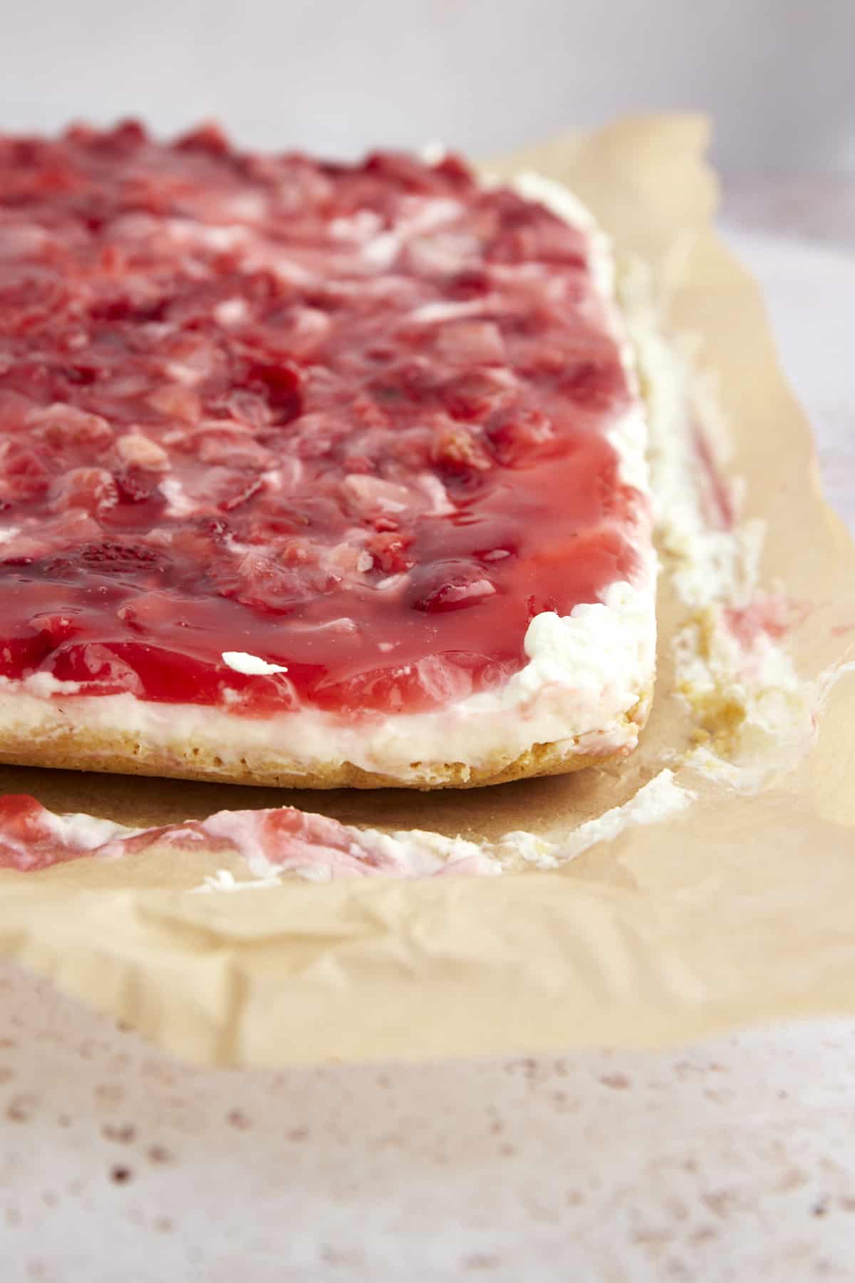 An uncut slab of strawberry cheesecake bars. 
