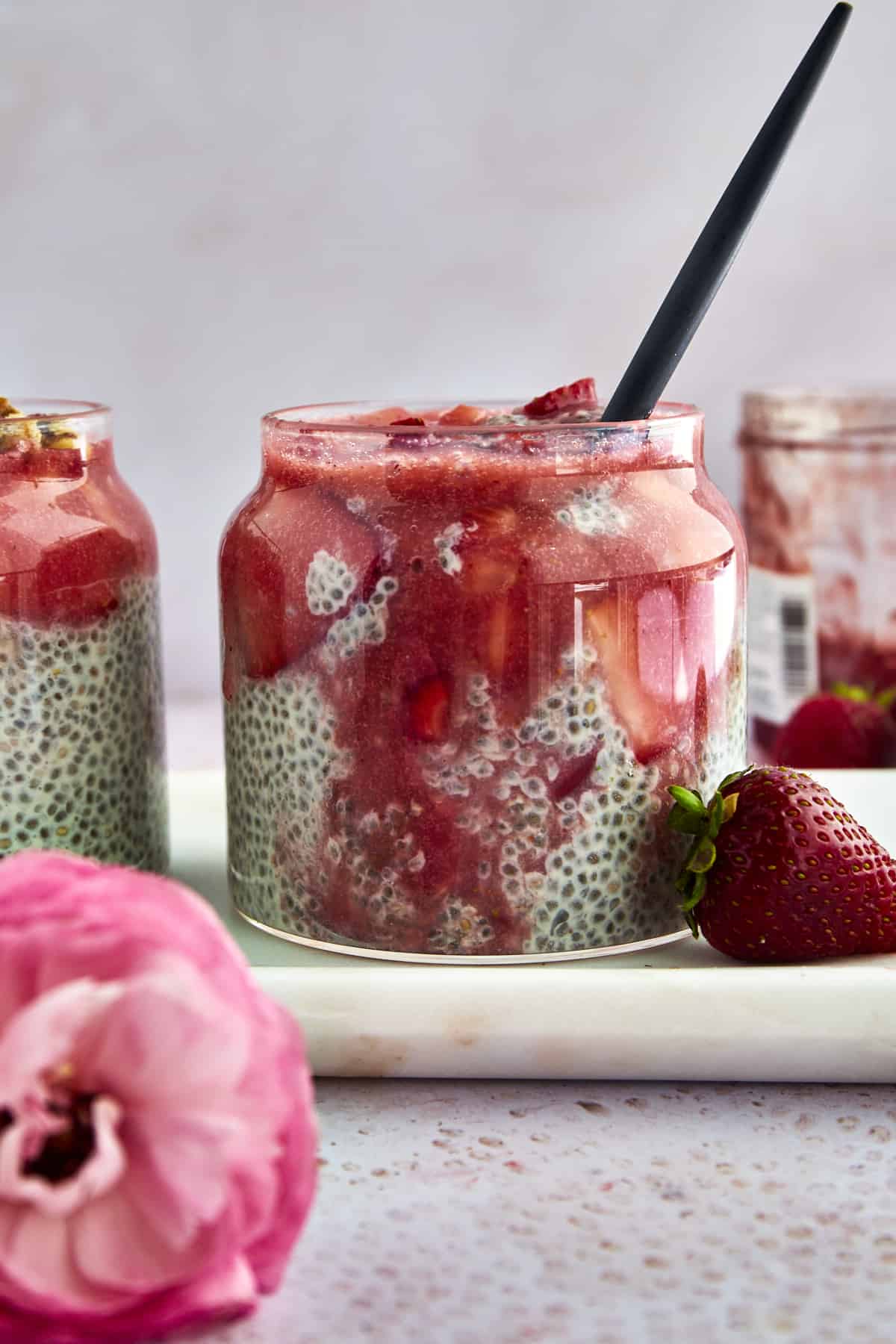 A jar of strawberry chia pudding with strawberry puree mixed in.