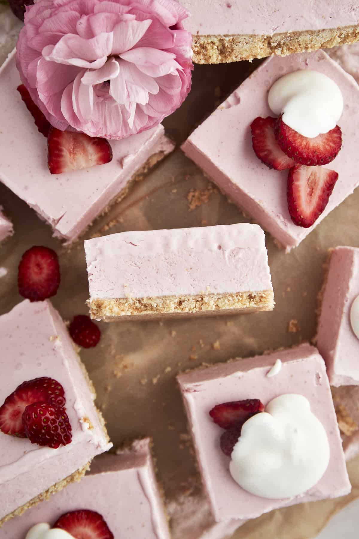No-bake strawberry cheesecake squares topped with strawberries and whipped cream. 