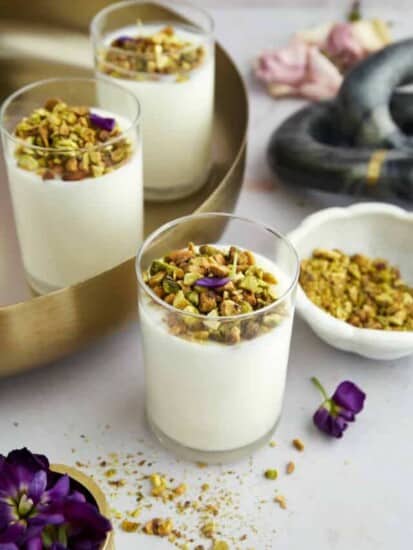 Jars of coconut rice pudding topped with crushed pistachios.