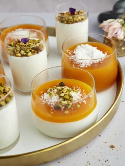 Pots of Muhallebi Amardeen Pudding topped with coconut flakes and chopped pistachios.
