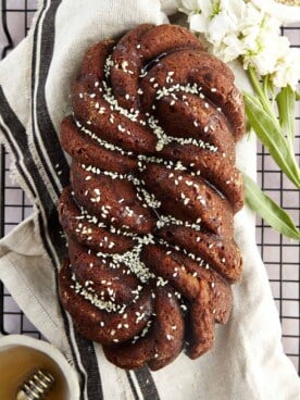 Overhead image of a loaf of tahini banana bread topped with white sesame seeds.