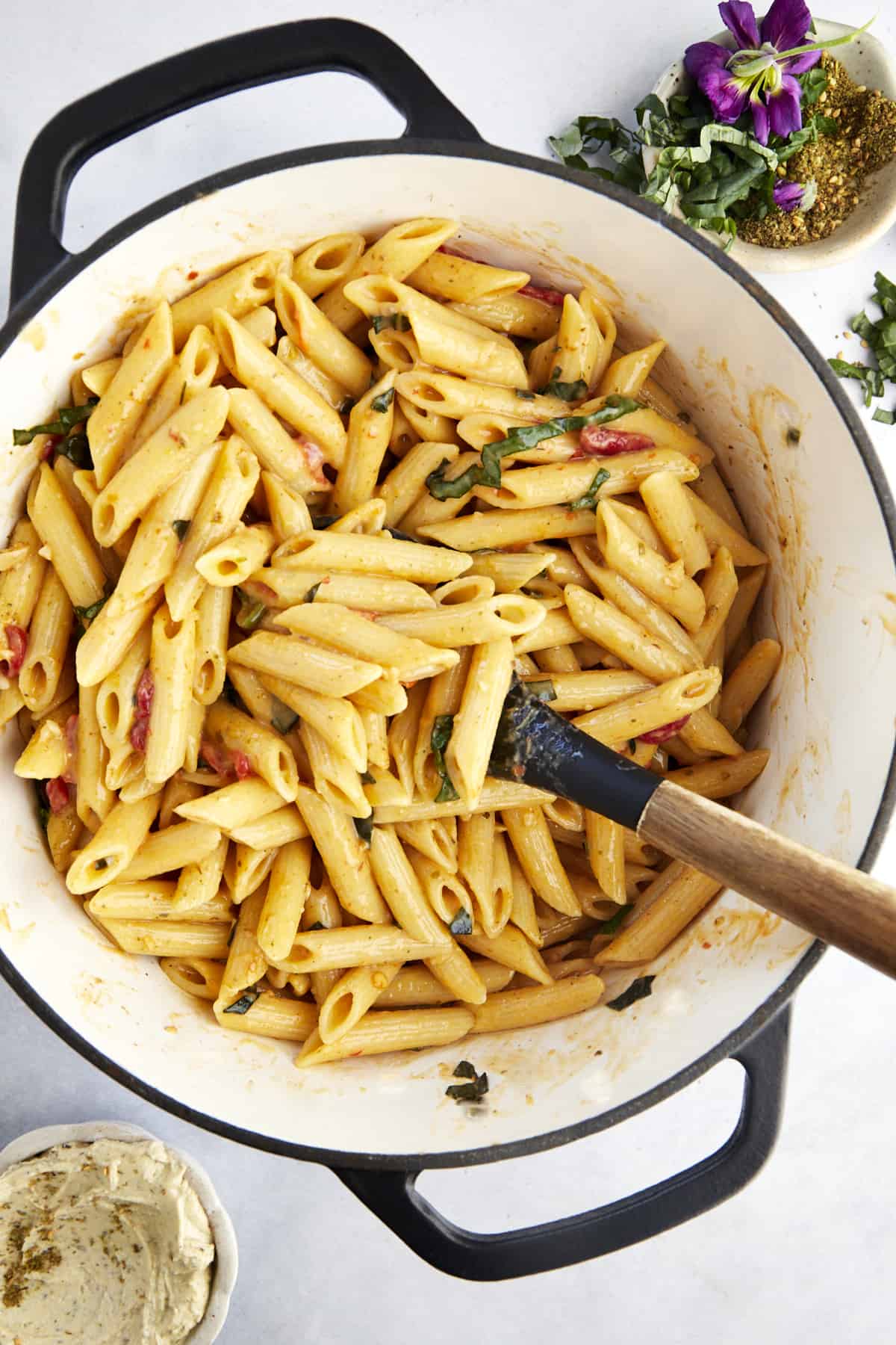 a rubber spatula stirring hummus pasta in a large pot 