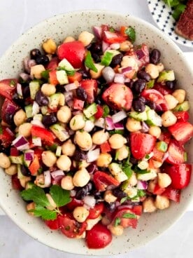 A bowl of Balela Salad with black beans, chickpeas, and veggies.