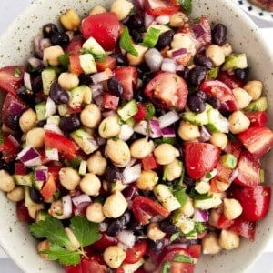 A bowl of Balela Salad with black beans, chickpeas, and veggies.