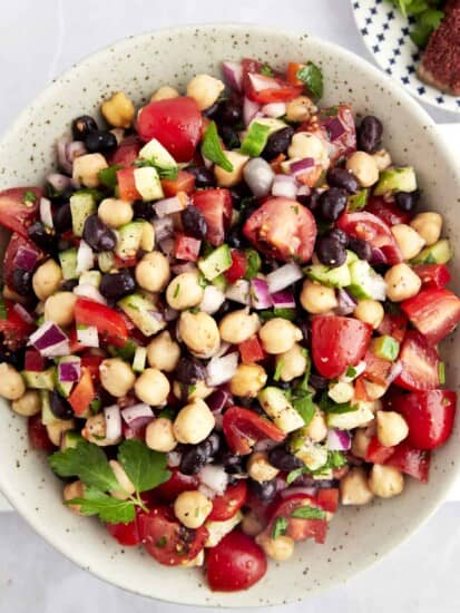A bowl of Balela Salad with black beans, chickpeas, and veggies.
