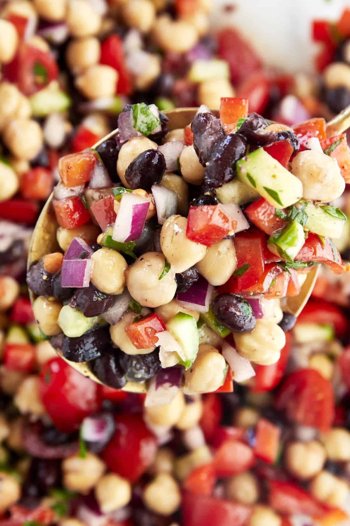 A spoon scooping up a portion of Balela Salad. 