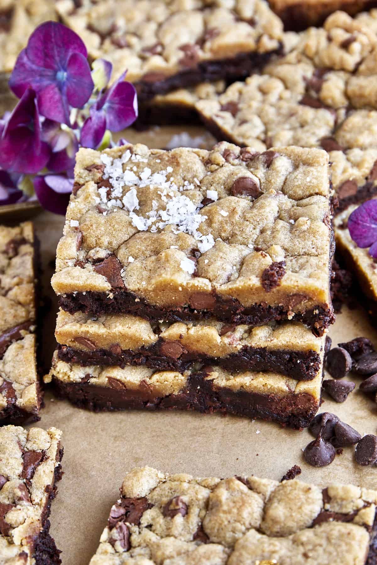 A stack of three brookie bars on top of each other topped with sea salt flakes. 